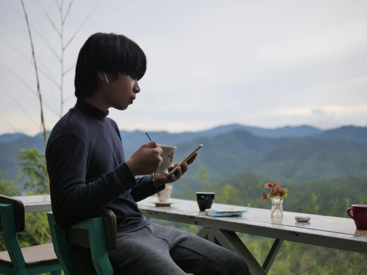 a young man that is sitting in a chair at a table