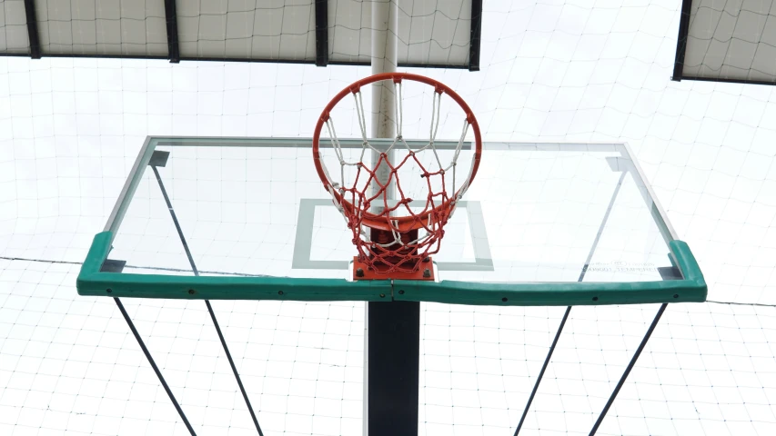 a basketball hoop inside of a glass court with net on it