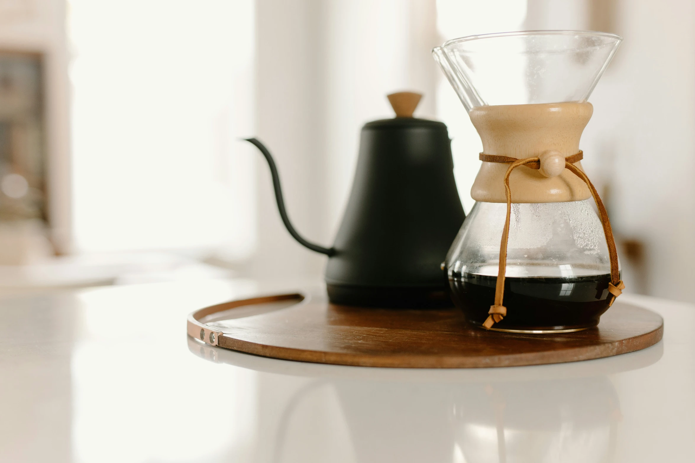 a glass coffee pot and some coffee being poured into it