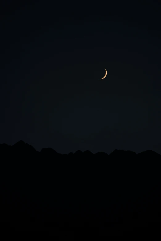 a crescente moon is shown over the hills