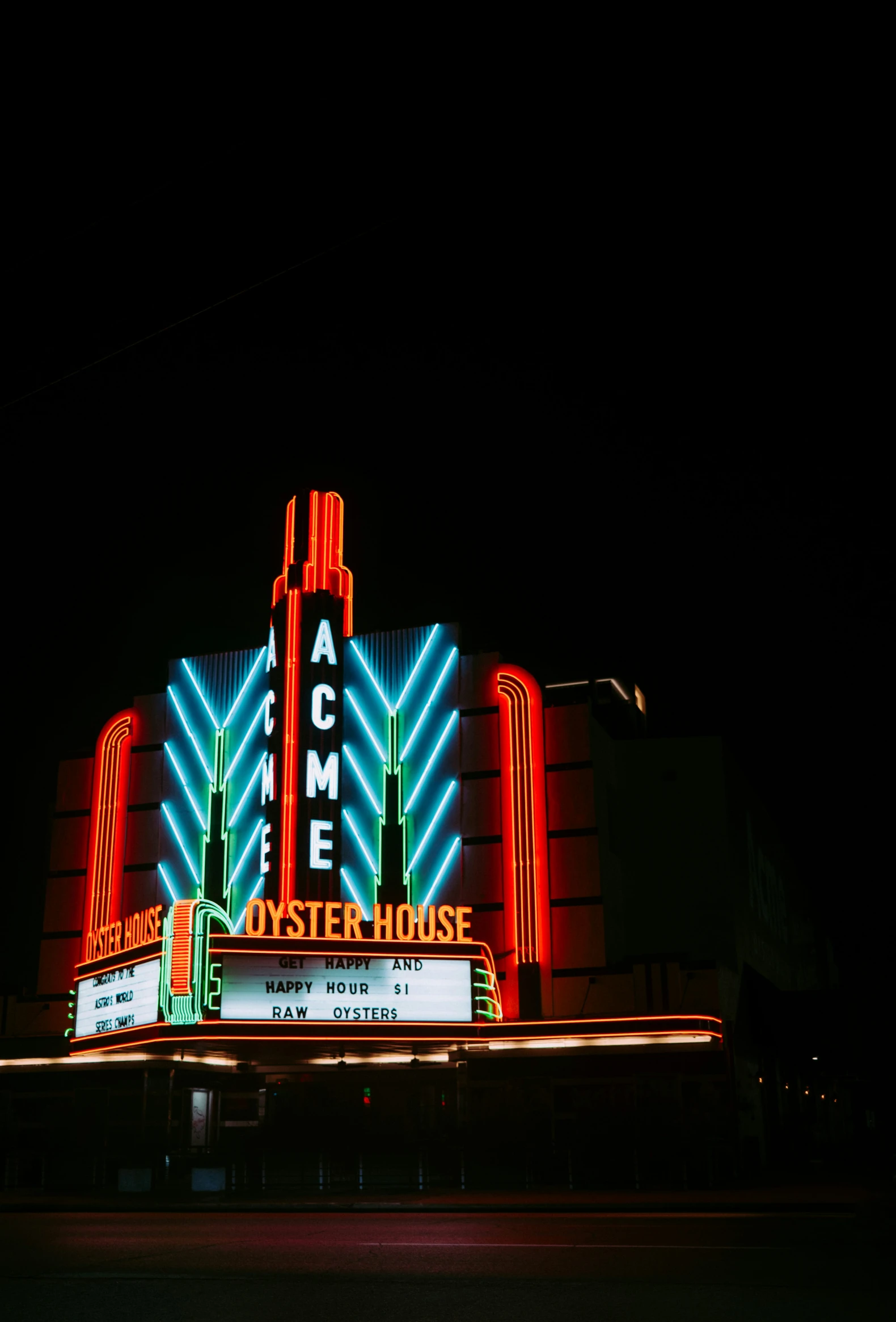 an illuminated theatre at night with signage lit up