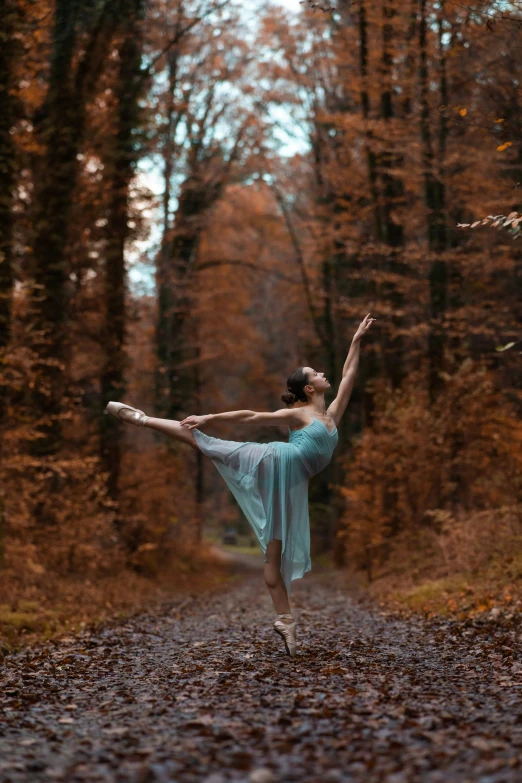 the young woman is dancing in the woods