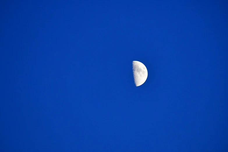 the moon is partially obscured by the dark blue sky