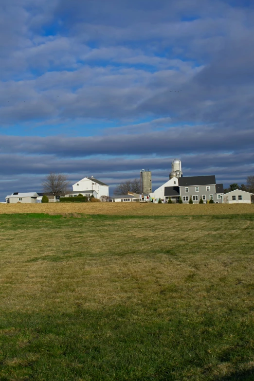 a large farm with white houses behind it