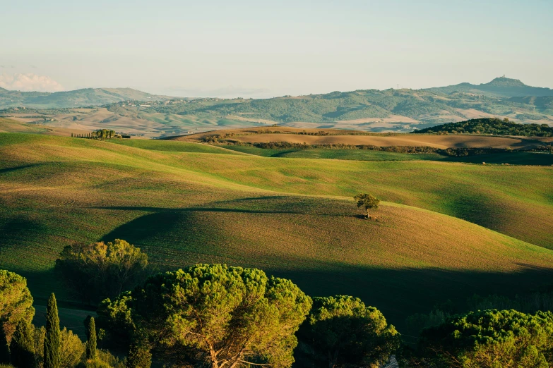 an area covered with hills, trees and a field