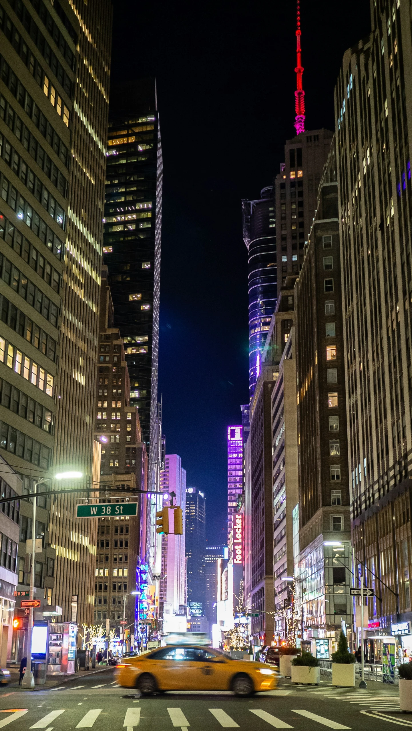 a yellow cab drives through a big city at night