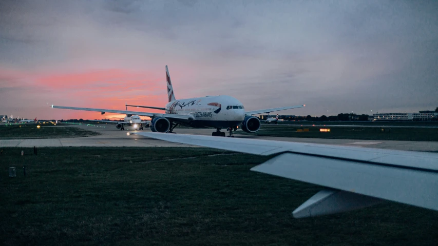 an airplane landing on a runway during the evening