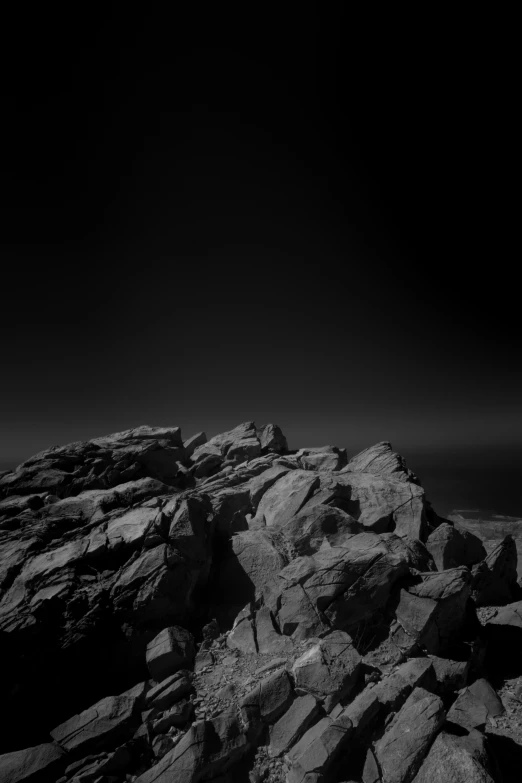 a rock formation on top of a hill near the ocean