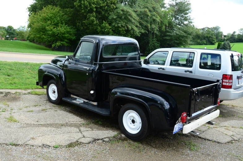 a black truck parked in front of a silver car