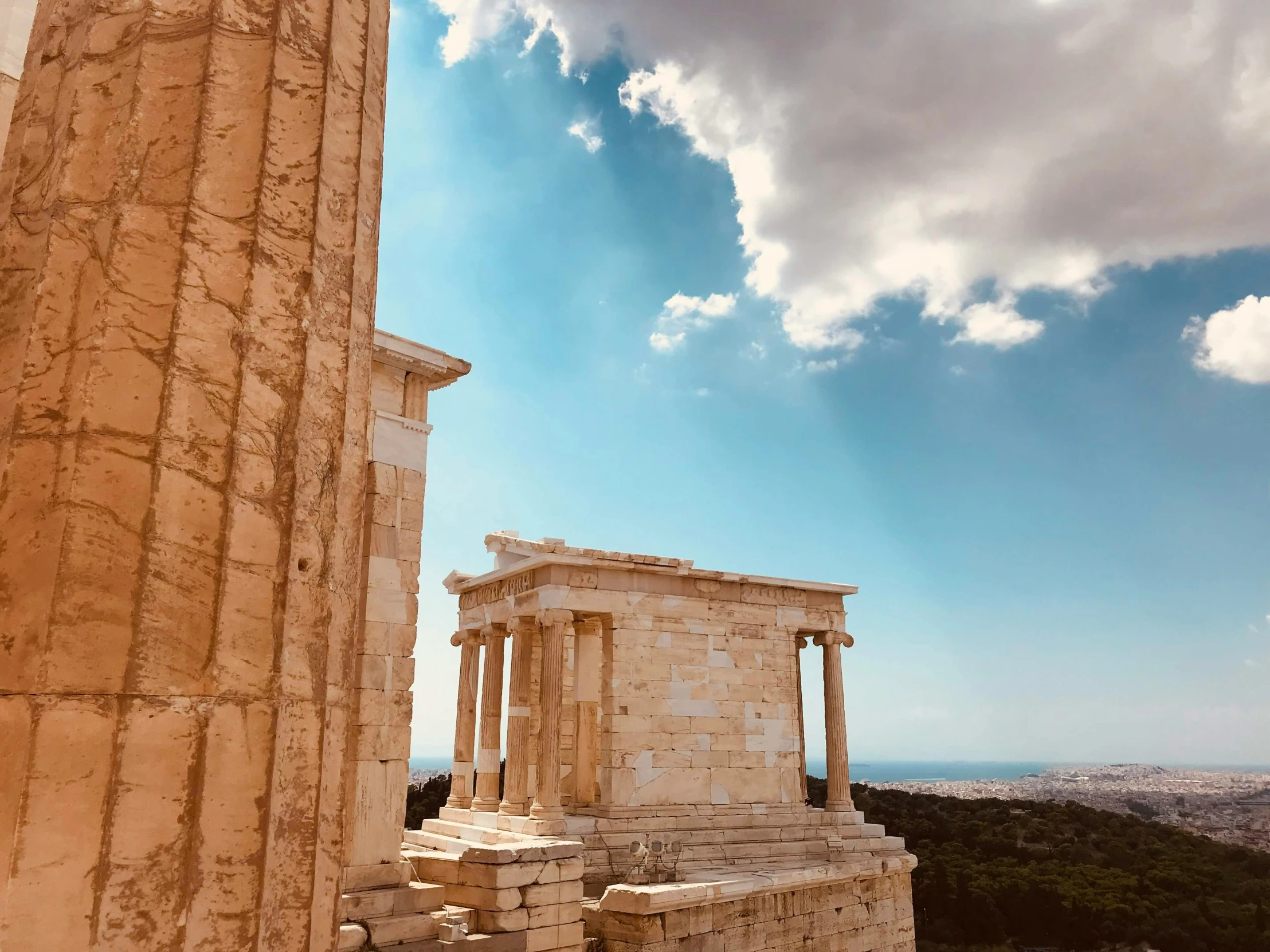 two very tall pillars near each other with clouds above