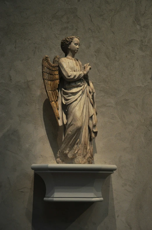 an angel statue that is sitting on top of a shelf