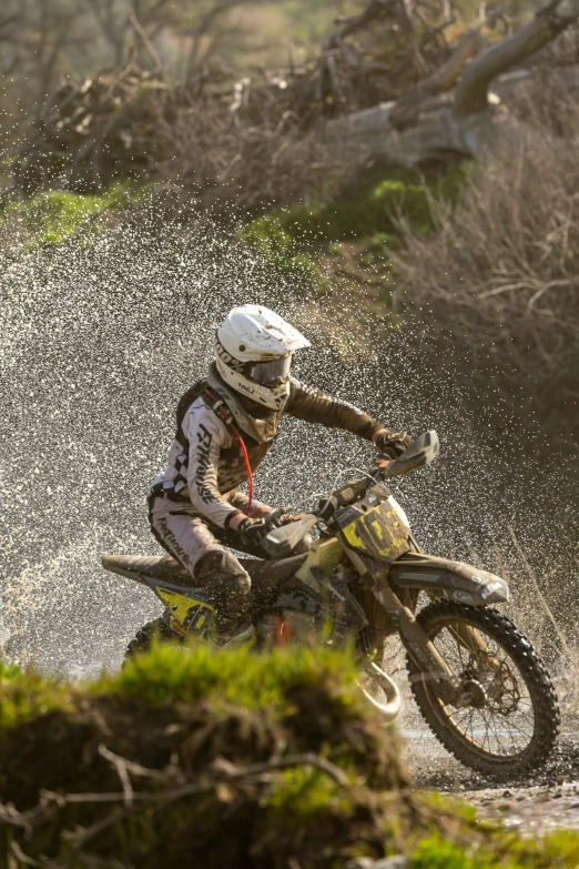 a person on a dirt bike riding through some water