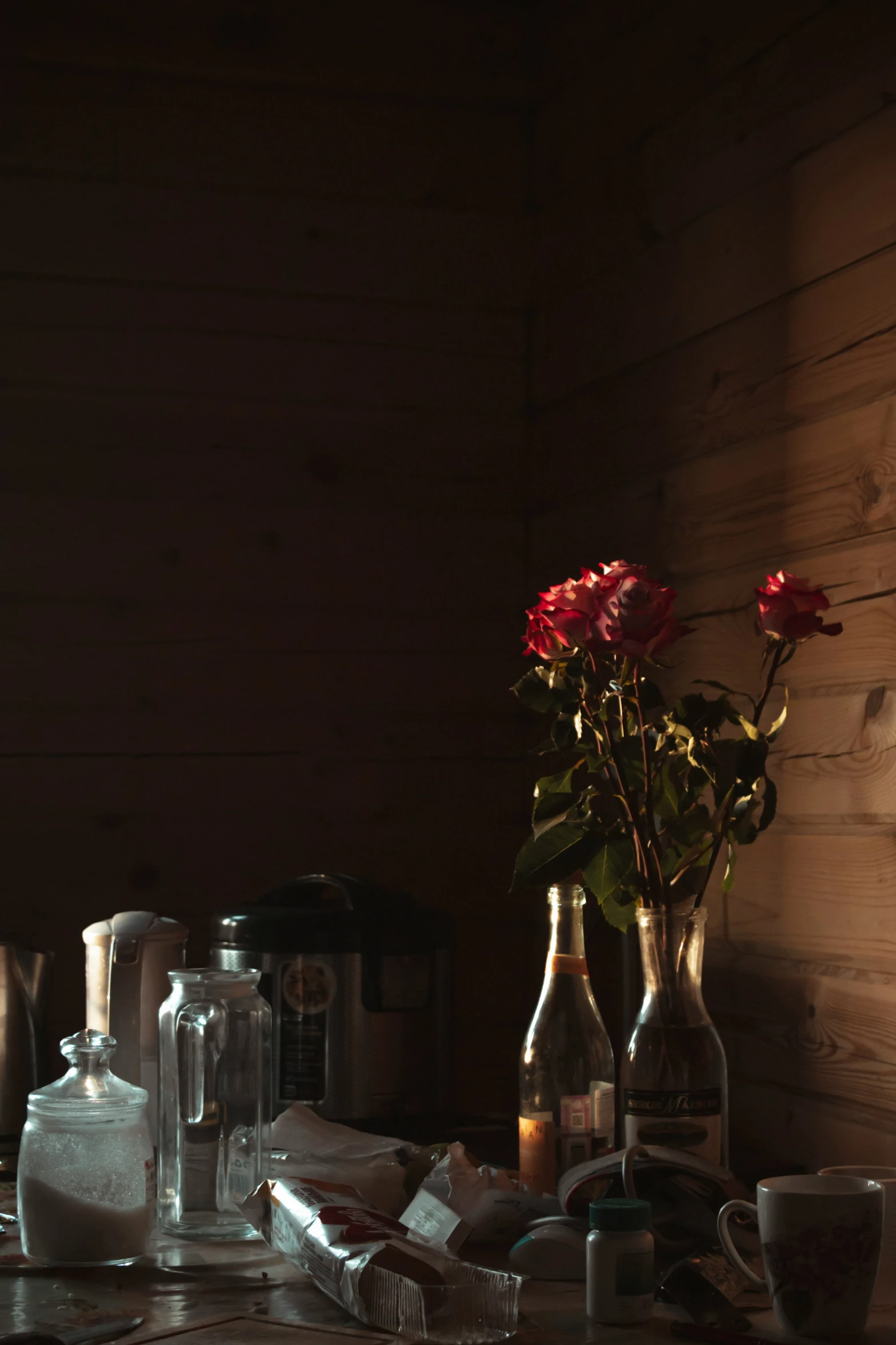 a table with two vases filled with flowers next to candles