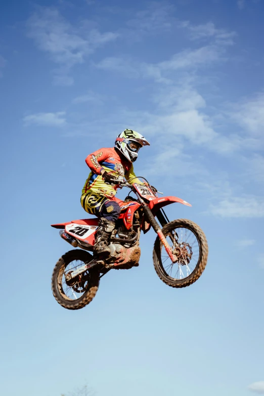 a person is jumping over a motorcycle in the air