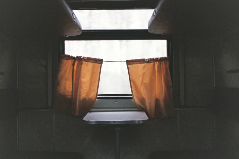 a window has a curtain and is partially closed