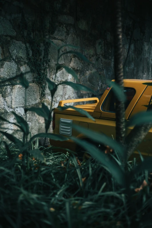 a close up of a yellow car with trees in the background