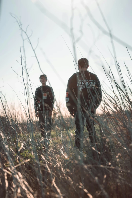 two men standing in tall dry grass with their faces slightly shut