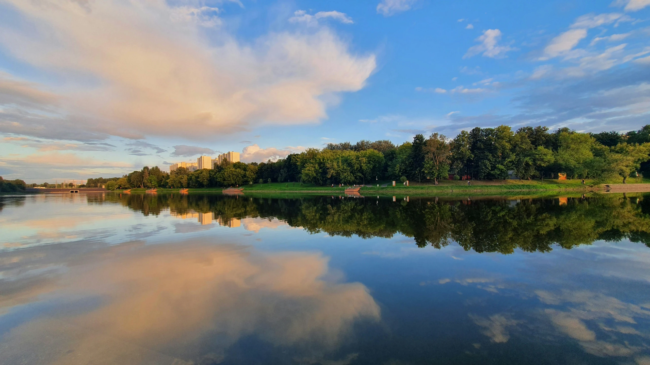 a pond is pictured with blue water and green trees