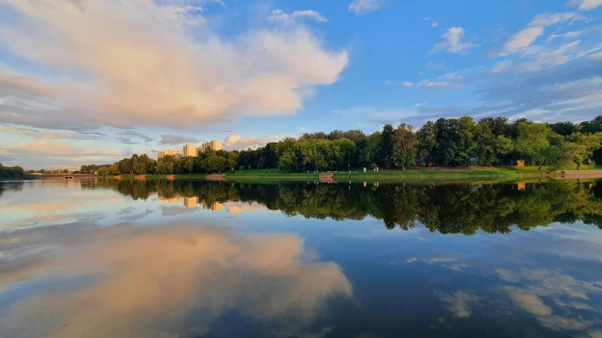 a pond is pictured with blue water and green trees