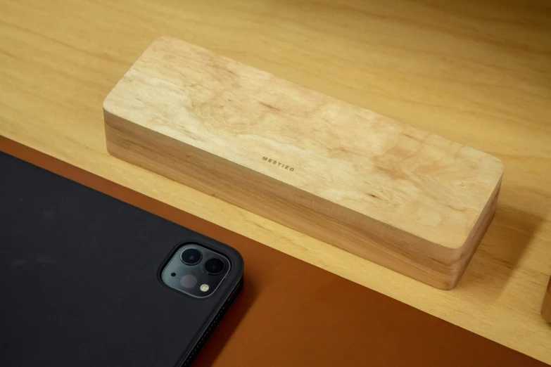 two electronics are placed near a wood phone stand