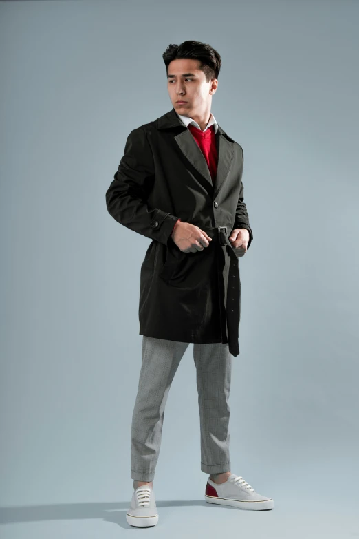a young man in grey pants, red shirt and coat