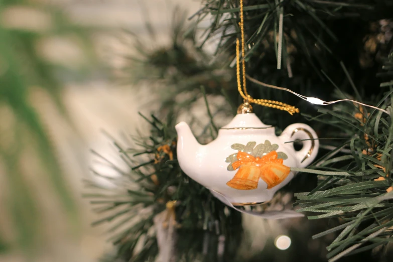 a tea pot ornament hanging on a tree