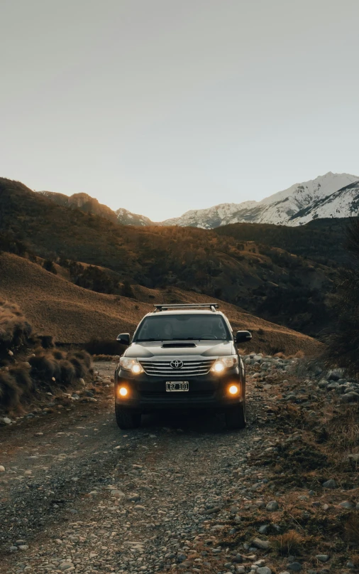 a vehicle that is driving through the wilderness