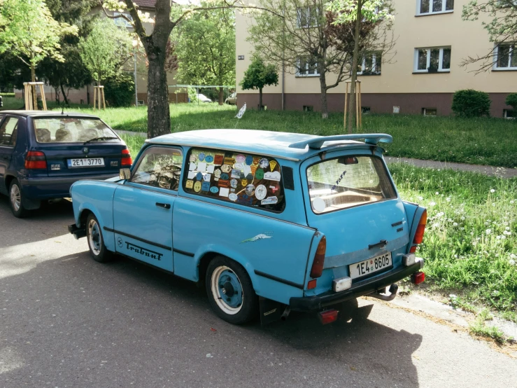 an old and rusty blue car parked on the side of a street