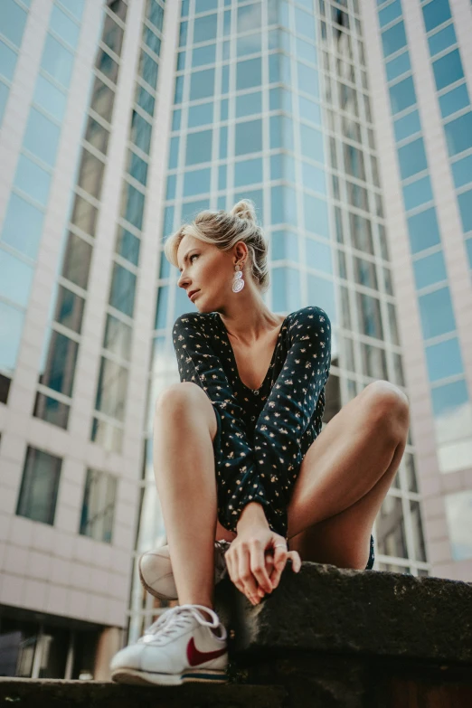 a woman in floral shirt sitting on concrete steps near a building