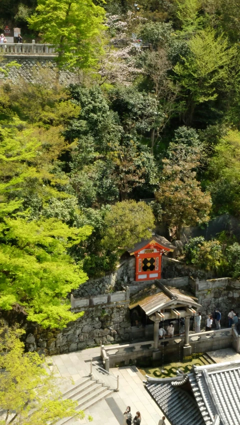 a shrine in the middle of trees and people walking by