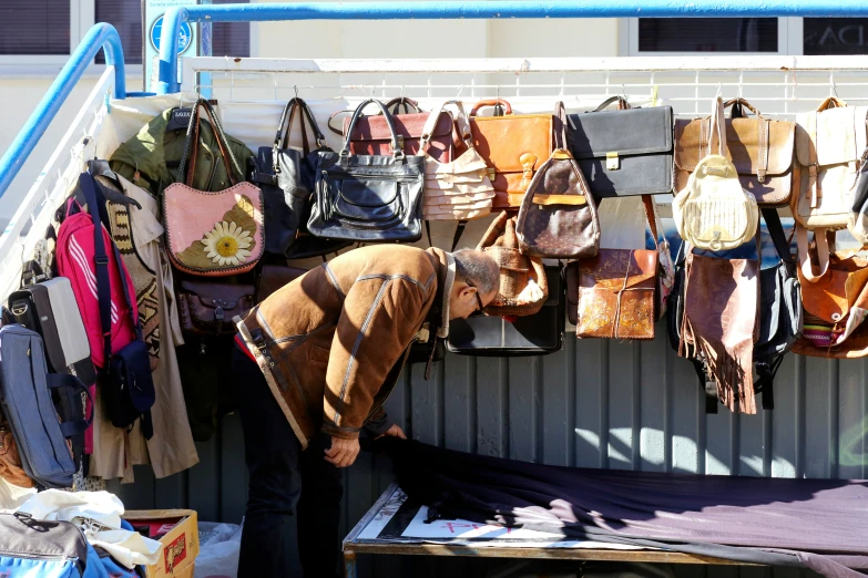 woman standing near a display of handmade bags