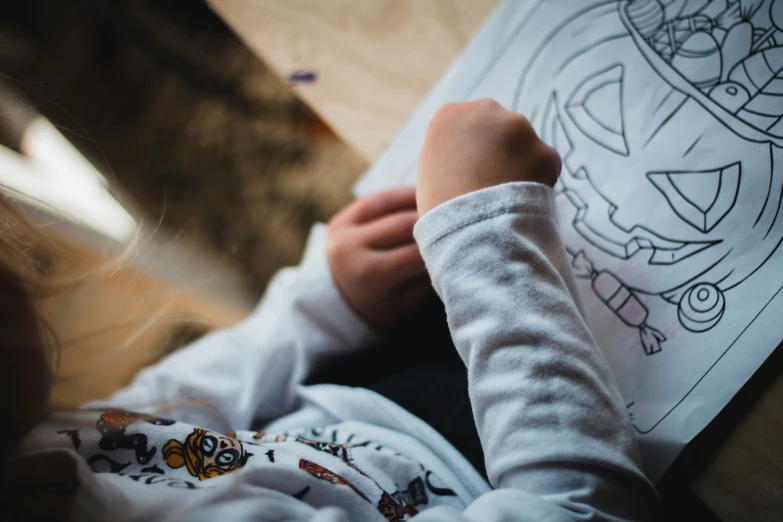 a young child laying down with a drawing