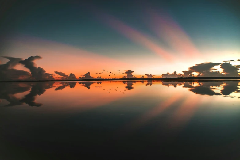 there is a beautiful sunset and clouds reflected in the water