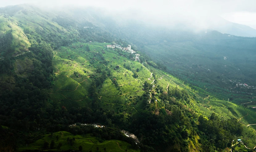 an aerial view of green mountains and clouds