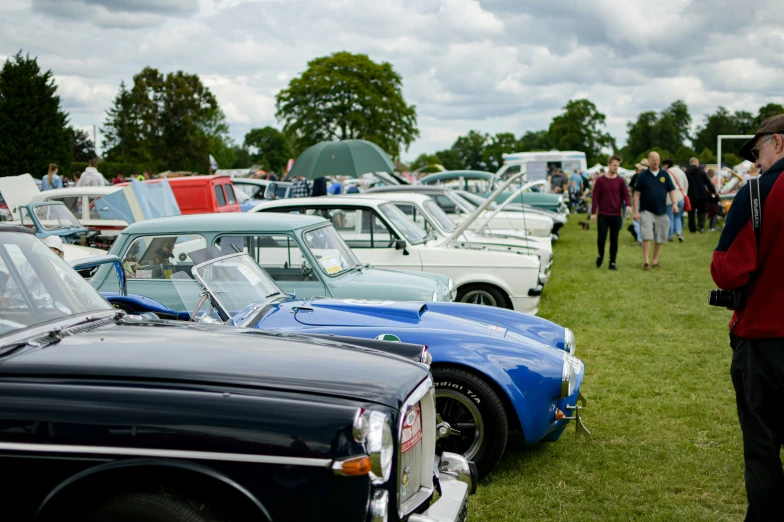 a man looking at some cars in a line