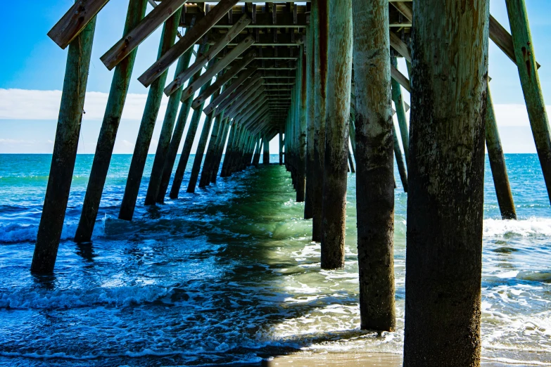 a pier stretching into the ocean from the beach