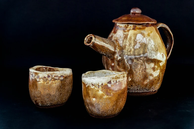 several pieces of pottery sitting on a black background