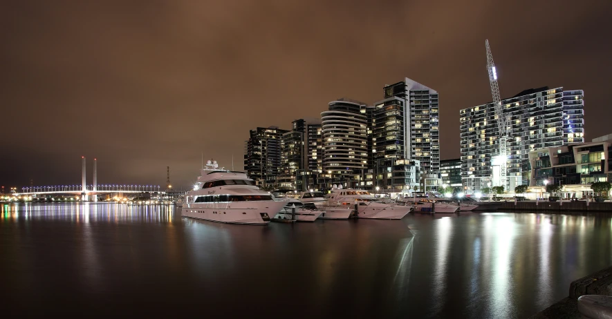 several large boats are parked in a harbor with buildings in the background