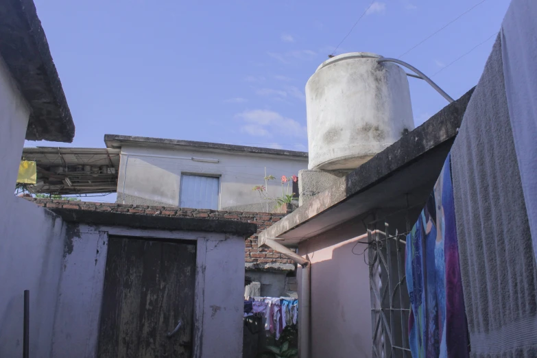 some buildings and an old water tank with clothes hanging out to dry