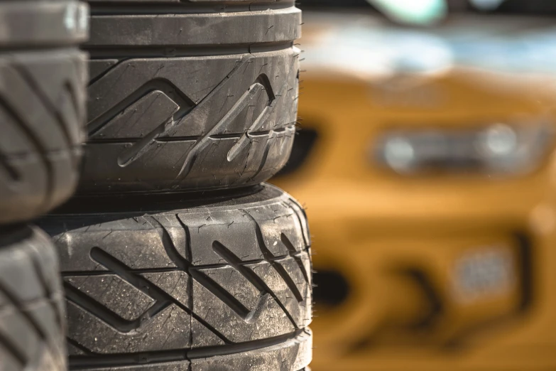 several tires sitting on top of each other near a taxi