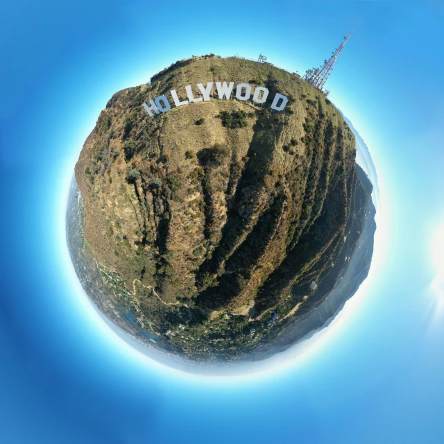 an aerial view of a hollywood sign on a small, grassy hill