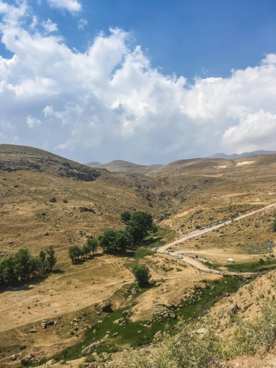 a couple of people ride horses on a trail