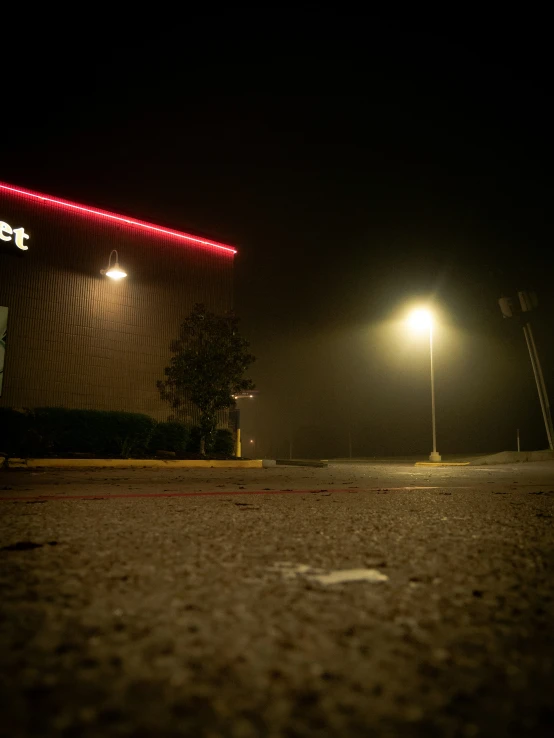 there is a parking lot with a lit neon sign on it