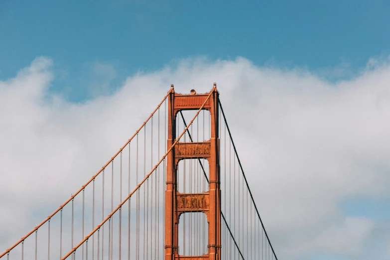 a brown bridge under a cloudy sky