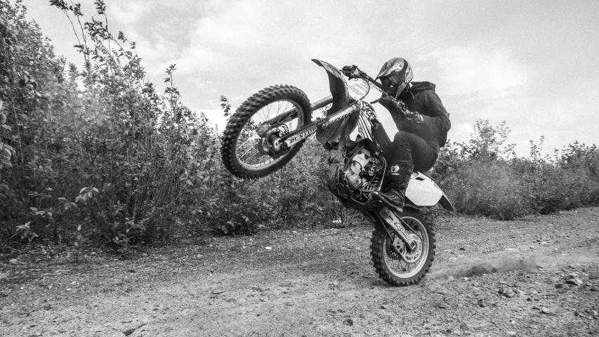 a man on a motorcycle does an air trick