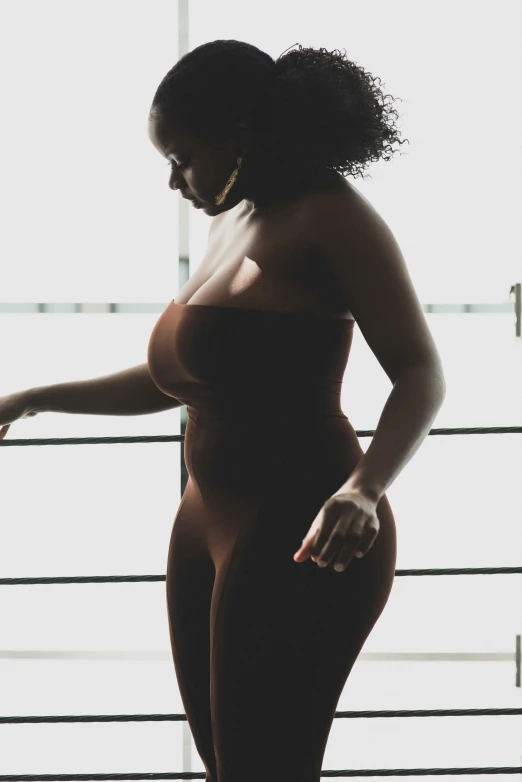 a black woman is  standing next to a window