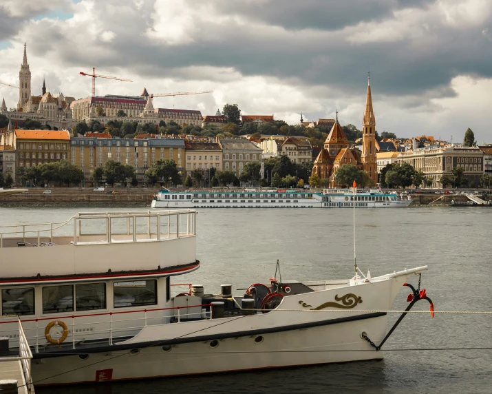 an old cruise ship with a sail in front of a beautiful city