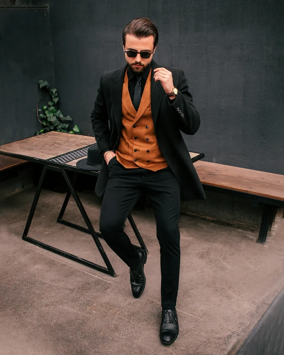 a man in black and brown is posing