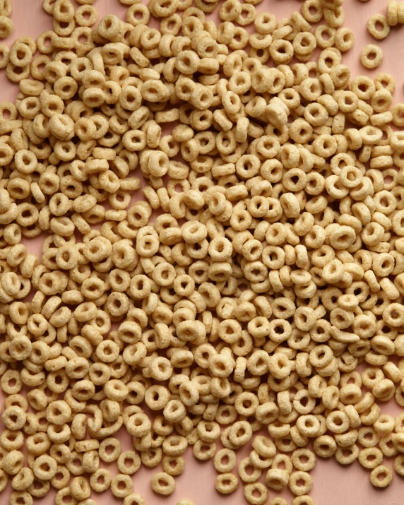 several different kinds of cereal are spread out on a pink surface