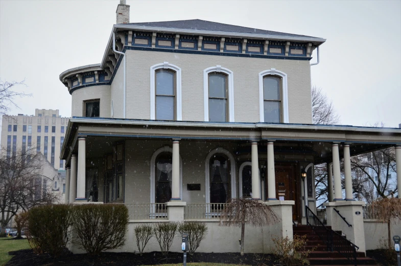 two storey house with several windows and two front stairs